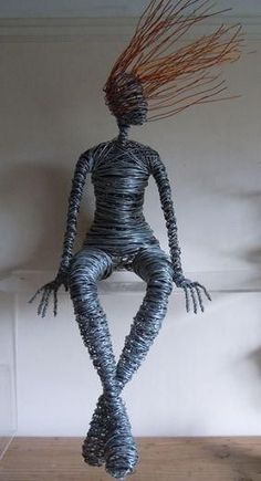 a wire sculpture sitting on top of a wooden table