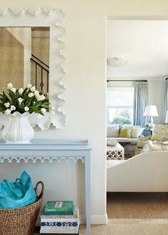 a living room filled with furniture and a painting on the wall above a console table