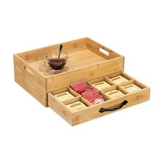 a bamboo tray with four compartments and two cups on it, sitting next to each other