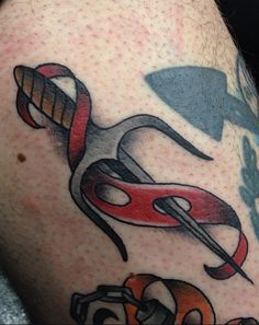 a man with a tattoo on his arm has scissors and wrenches in the shape of an arrow