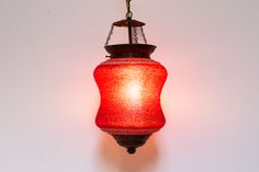 a red lamp hanging from a ceiling in a room