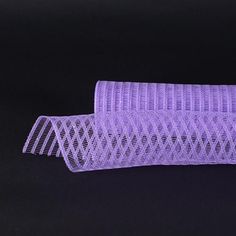 a roll of purple mesh sitting on top of a black surface