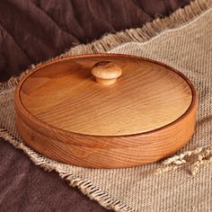 a wooden bowl on a brown cloth with a small wood object in the middle of it