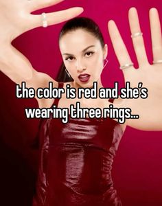 the color is red and she's wearing three ring set on her finger,