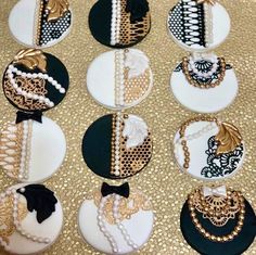 twelve decorated cupcakes with black and white lace, pearls, and gold accents