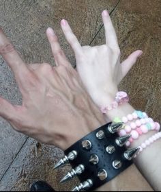 two hands with different bracelets on their wrists