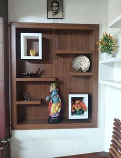 a wooden shelf with pictures and figurines on it