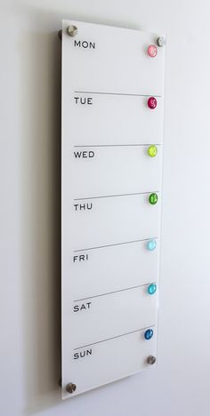 a white sign with different colored buttons on it's side and the words moon, tue, wed, thu, fri, sat sun