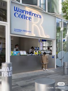 the front of a coffee shop with people standing at the counter