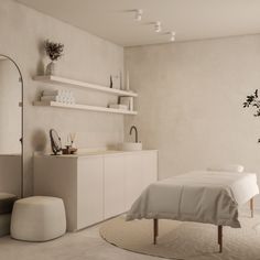 a white bed sitting in a bedroom next to a dresser and mirror on top of a wall