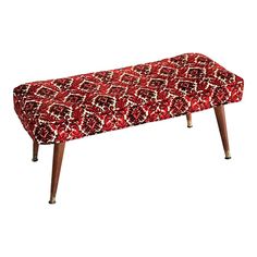 an upholstered bench with wooden legs and a red patterned seat cover on it