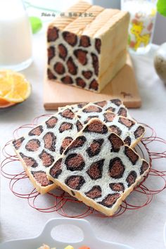 slices of cake with animal print on them sitting on a plate next to oranges