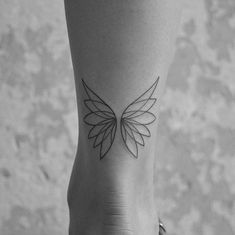 a woman's foot with a black and white tattoo design on the left ankle