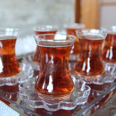 several glasses filled with liquid sitting on top of a tray