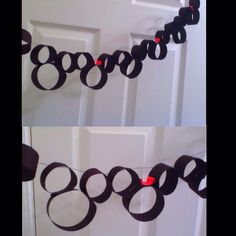 two pictures of black paper circles hanging from a string on the front door with red buttons