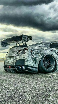 a camouflaged sports car is parked on the pavement