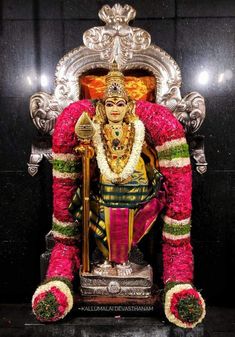 the statue is decorated with flowers and garlands