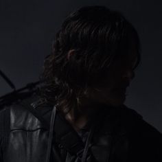 a man with long hair wearing a black leather jacket