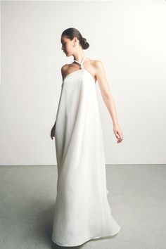 This dress is a luxurious and stylish piece. With flared, twisted shoulder straps and an A-line silhouette, this dress is perfect for any special occasion. Crafted from soft and lightweight silk, it will flatter your figure with a contemporary touch. Be the center of attention and look fabulous in this beautiful maxi dress. White Dress Editorial, Minimalist Bridesmaid Dress, Modern White Dress, Loose Wedding Dress, Wedding Sweater, Minimalist Gown, Bridal Shrug, Mean Blvd, Bridal Jacket