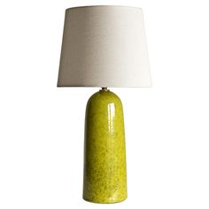 a yellow table lamp with a white shade on the base and a light in front of it