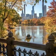 two people in a small boat on a river near the city's skyscrapers