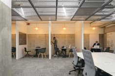 an office with two people working at desks and one person writing on the wall