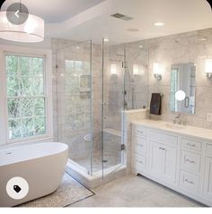 a bathroom with a tub, sink and large windows