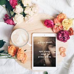 an ipad sitting on top of a table next to flowers