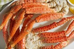 crab legs on a plate with lemon wedges