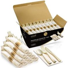 a set of white and gold dinnerware in a cardboard box with utensils