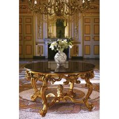 a fancy table in the middle of a room with chandelier and flowers on it