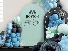 a bunch of balloons that are in front of a sign with boston is first one written on it