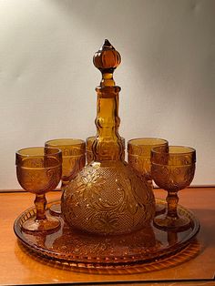 an old fashioned decanter set on a wooden table with wine goblets