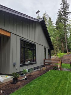 a house that is in the middle of some grass and plants on the side of it