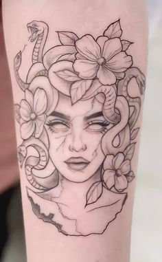 a woman's face with flowers and snakes on her arm