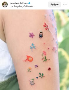 a woman's arm with small tattoos on it