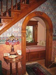 the stairs are made of wood and have intricate designs on them, along with a small table