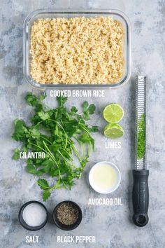 ingredients to make mexican rice laid out on a gray surface with limes, cilantro, salt, and seasonings