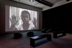 an empty room with two black chairs and a projector screen