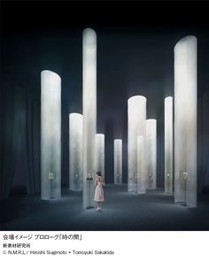 a woman in a white dress standing between tall pillars with light coming from the top