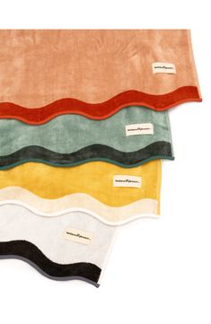 four different colors of towels on top of each other, with labels attached to them