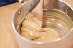 a person mixing batter in a metal bowl