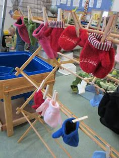 several pairs of socks hanging on clothes pins in a room filled with toys and other items