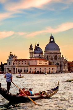 two gondolas with people on them in the water next to an old building