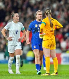 two female soccer players are talking to each other