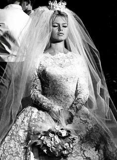 an old photo of a woman in a wedding dress with a veil on her head