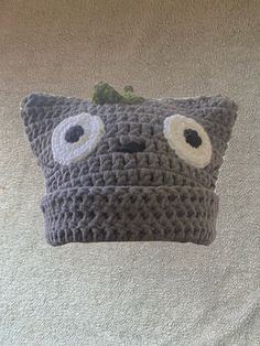 a crocheted pillow with eyes on it