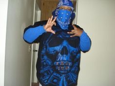 a man wearing a blue skull shirt with a bandana covering his face and hands