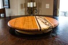 a surfboard sitting on top of a wooden table in front of a chandelier