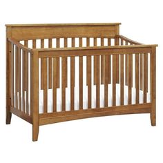 a small wooden crib with white sheets on the bottom and side rails, against a white background